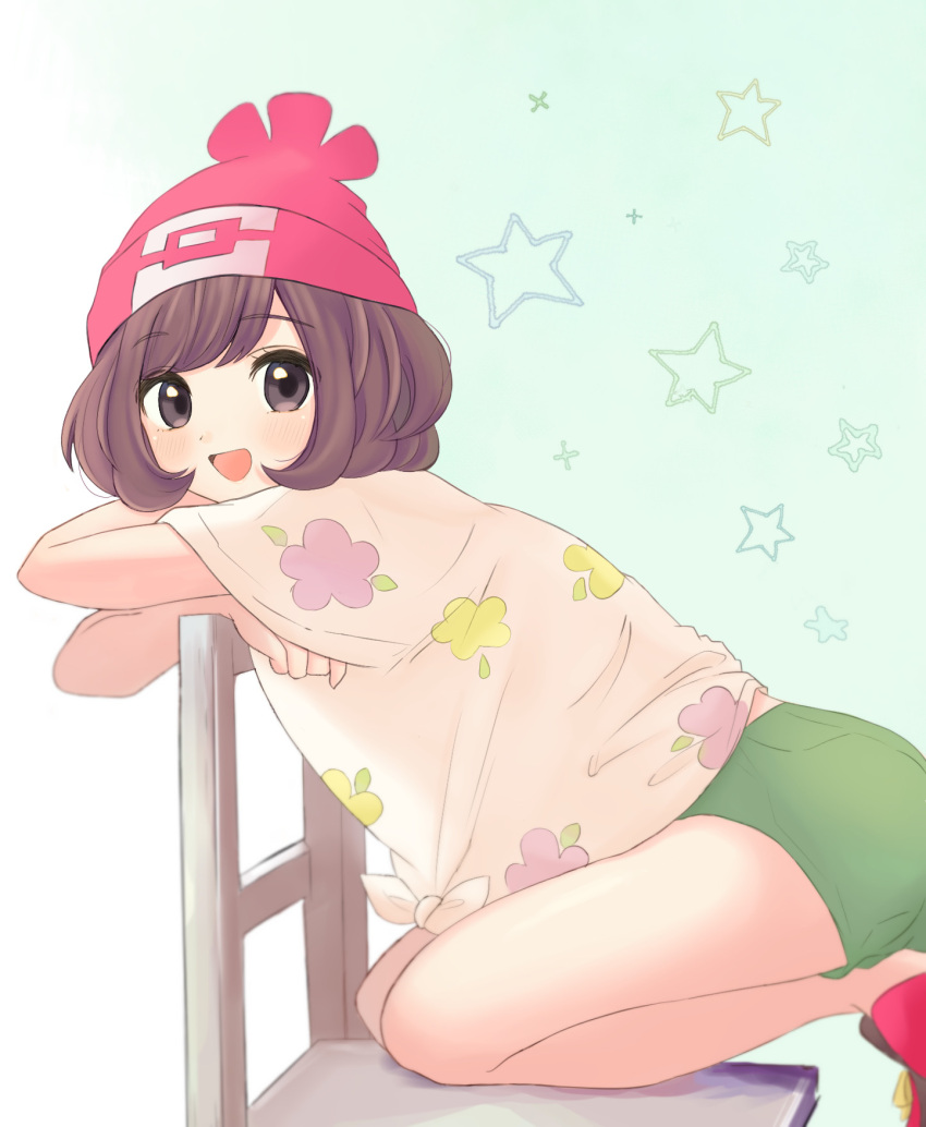 1girl :d bangs beanie blush brown_eyes brown_hair chair commentary eyebrows_visible_through_hair eyelashes floral_print from_side green_shorts hat highres kneeling looking_at_viewer nasakixoc open_mouth pokemon pokemon_(game) pokemon_sm red_footwear red_headwear selene_(pokemon) shirt shoes short_hair short_sleeves shorts smile solo star_(symbol) tongue