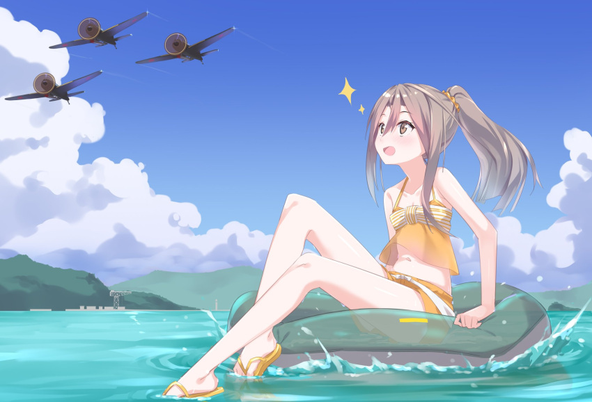 1girl aircraft alternate_costume bangs blush brown_eyes clouds day eyebrows_visible_through_hair flip-flops full_body gedoo_(gedo) hair_ornament hair_scrunchie high_ponytail highres innertube kantai_collection light_brown_hair long_hair mountain navel ocean open_mouth outdoors ponytail sandals scrunchie shorts sitting sky sleeveless solo sparkle swimsuit water zuihou_(kantai_collection)