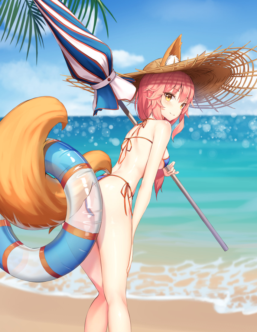 1girl absurdres animal_ear_fluff animal_ears beach beach_umbrella bikini blue_bikini blush breasts commentary commentary_request demis0ra eyebrows_visible_through_hair fate/grand_order fate_(series) fox_ears fox_girl fox_tail hat highres innertube large_breasts looking_at_viewer ocean outdoors palm_leaf palm_tree parasol pink_hair side-tie_bikini solo straw_hat summer swimsuit tail tamamo_(fate)_(all) tamamo_no_mae_(swimsuit_lancer)_(fate) tree umbrella yellow_eyes