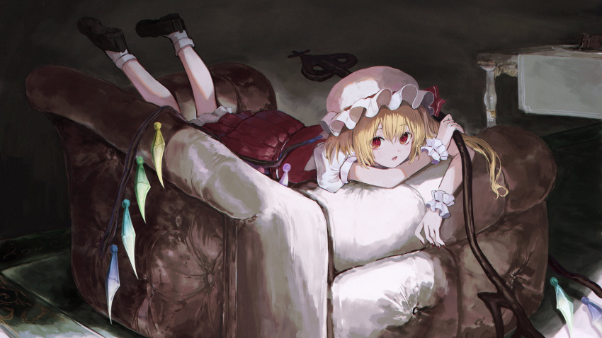 1girl absurdres bangs black_footwear blonde_hair crystal eyebrows_visible_through_hair flandre_scarlet full_body happiness_lilys hat hat_ribbon highres holding indoors laevatein_(touhou) looking_at_viewer lying medium_hair mob_cap on_chair on_stomach one_side_up open_mouth puffy_short_sleeves puffy_sleeves red_eyes red_ribbon ribbon short_sleeves solo table touhou white_headwear white_legwear wings wrist_cuffs