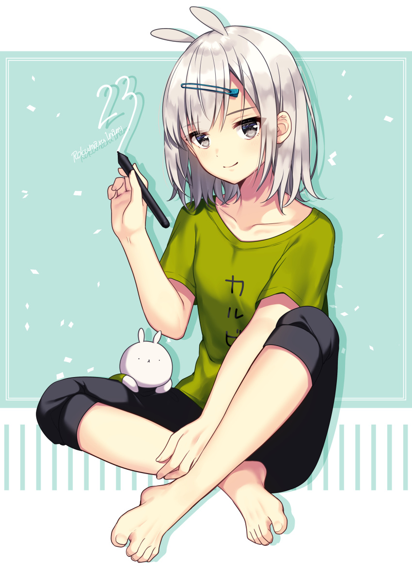 1girl absurdres animal_ears bangs barefoot black_shorts blush closed_mouth clothes_writing collarbone commentary_request eyebrows_visible_through_hair feet full_body green_shirt grey_eyes hair_between_eyes hair_ornament hairclip highres holding holding_stylus ichiren_namiro original rabbit_ears shirt short_sleeves shorts signature silver_hair sitting smile solo stylus toenails translated