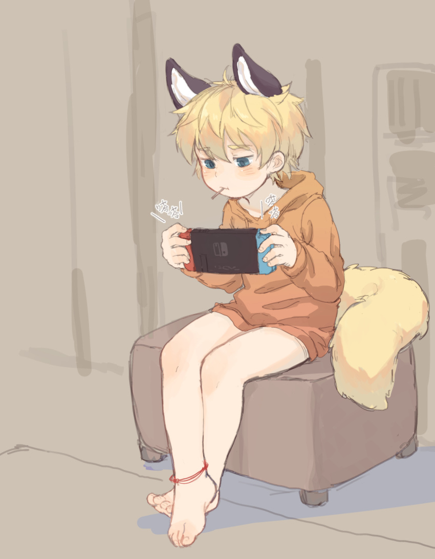 1boy absurdres animal_ears barefoot blonde_hair blue_eyes chinese_text fox_boy fox_ears fox_tail game_console handheld_game_console highres hood hoodie indoors male_focus nintendo nintendo_switch original playing_games shotac0n sitting solo tail