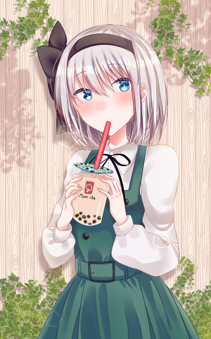 1girl absurdres bangs black_hairband black_neckwear black_ribbon blue_eyes blush bubble_tea commentary_request cowboy_shot cup disposable_cup dress drinking drinking_straw eyebrows_visible_through_hair green_belt green_dress hair_between_eyes hair_ribbon hairband highres holding holding_cup konpaku_youmu leaf long_sleeves looking_at_viewer neck_ribbon otowa_(otoha4634) ribbon shadow shirt short_hair silver_hair solo standing touhou white_shirt