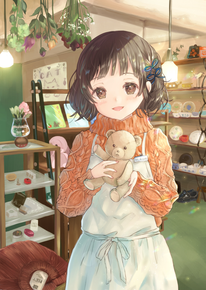 1girl apron arms_up bangs black_hair brown_eyes bunapi_(bunapii) ceiling_light commentary_request cup eyebrows_visible_through_hair flower greeting_card hair_ribbon head_tilt highres holding holding_stuffed_animal light_particles long_sleeves looking_at_viewer name_tag open_mouth orange_sweater original parted_lips plate ribbon shelf shop short_hair solo stuffed_animal stuffed_bunny stuffed_toy sweater teacup teddy_bear vase