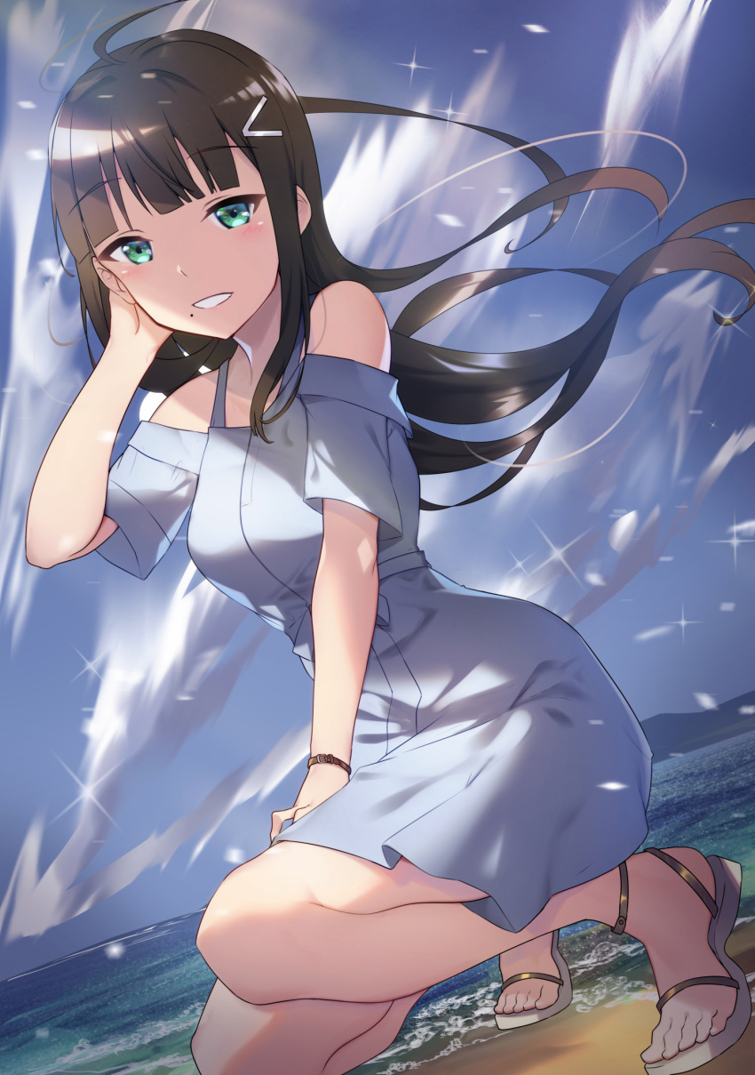 1girl ahoge bangs beach black_hair blue_dress blue_sky blunt_bangs blush clouds commentary_request day dress dutch_angle eyebrows_visible_through_hair floating_hair green_eyes hair_ornament hairclip hand_in_hair hand_up highres kurosawa_dia long_hair love_live! love_live!_sunshine!! mole mole_under_mouth ocean outdoors parted_lips sandals short_sleeves sky smile solo sparkle squatting water white_footwear wind wristband yamaori_(yamaorimon)