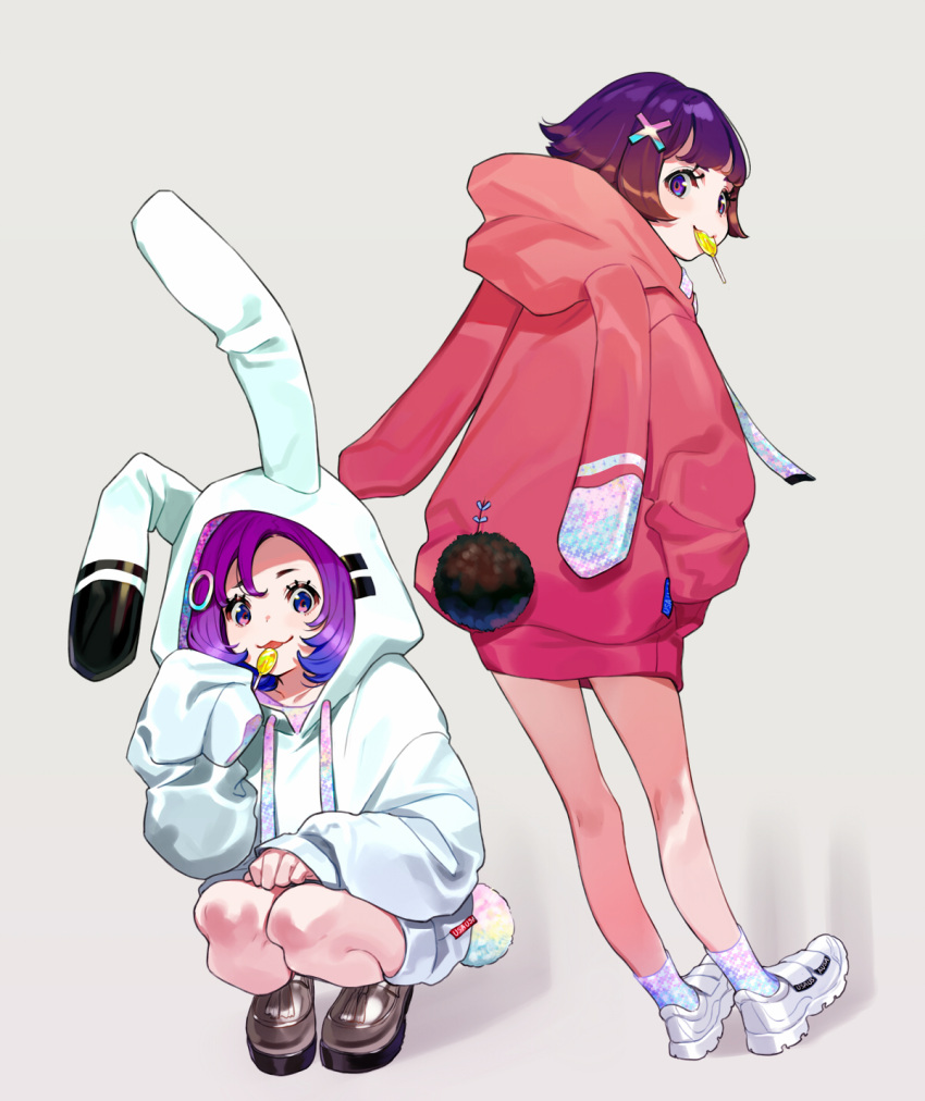 2girls animal_ears animal_hood bangs brown_footwear bunny_hood bunny_tail candy commentary_request drawstring fake_animal_ears fake_tail food food_in_mouth grey_background hair_ornament highres holding holding_food holding_lollipop hood hood_up hoodie lollipop looking_at_viewer mouth_hold multiple_girls original purple_hair rabbit_ears red_hoodie shadow shoes socks squatting standing tail tongue tongue_out violet_eyes white_footwear white_hoodie x_hair_ornament yuu_(higashi_no_penguin)
