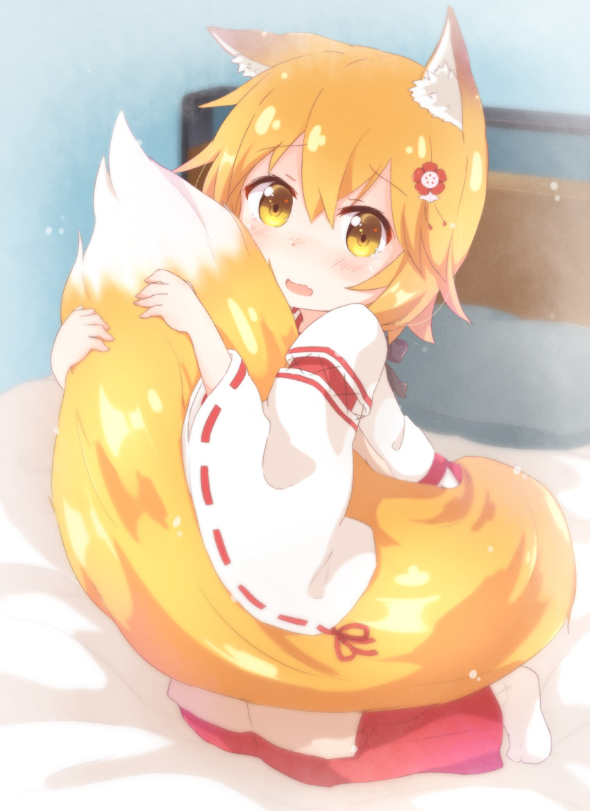 1girl animal_ear_fluff animal_ears apron araki495 bangs bed blonde_hair blurry blurry_background blush brown_apron brown_eyes commentary_request depth_of_field eyebrows_visible_through_hair fang flower fox_ears fox_girl fox_tail hair_between_eyes hair_flower hair_ornament hakama highres japanese_clothes kimono long_sleeves looking_at_viewer no_shoes on_bed open_mouth red_flower red_hakama ribbon-trimmed_sleeves ribbon_trim senko_(sewayaki_kitsune_no_senko-san) sewayaki_kitsune_no_senko-san socks solo tail tail_hug white_kimono white_legwear wide_sleeves