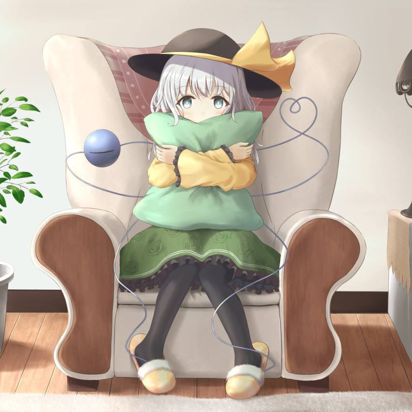 1girl armchair arms_up bangs black_headwear black_legwear bright_pupils chair commentary covered_mouth crossed_arms eyebrows_visible_through_hair floral_print frilled_sleeves frills green_eyes green_skirt hat hat_ribbon heart heart_of_string highres indoors knees_together_feet_apart komeiji_koishi lamp long_sleeves looking_at_viewer nakit pantyhose petticoat pillow pillow_hug plant potted_plant ribbon rose_print rug shirt short_hair silver_hair sitting skirt slippers solo third_eye touhou white_pupils wooden_floor yellow_footwear yellow_shirt