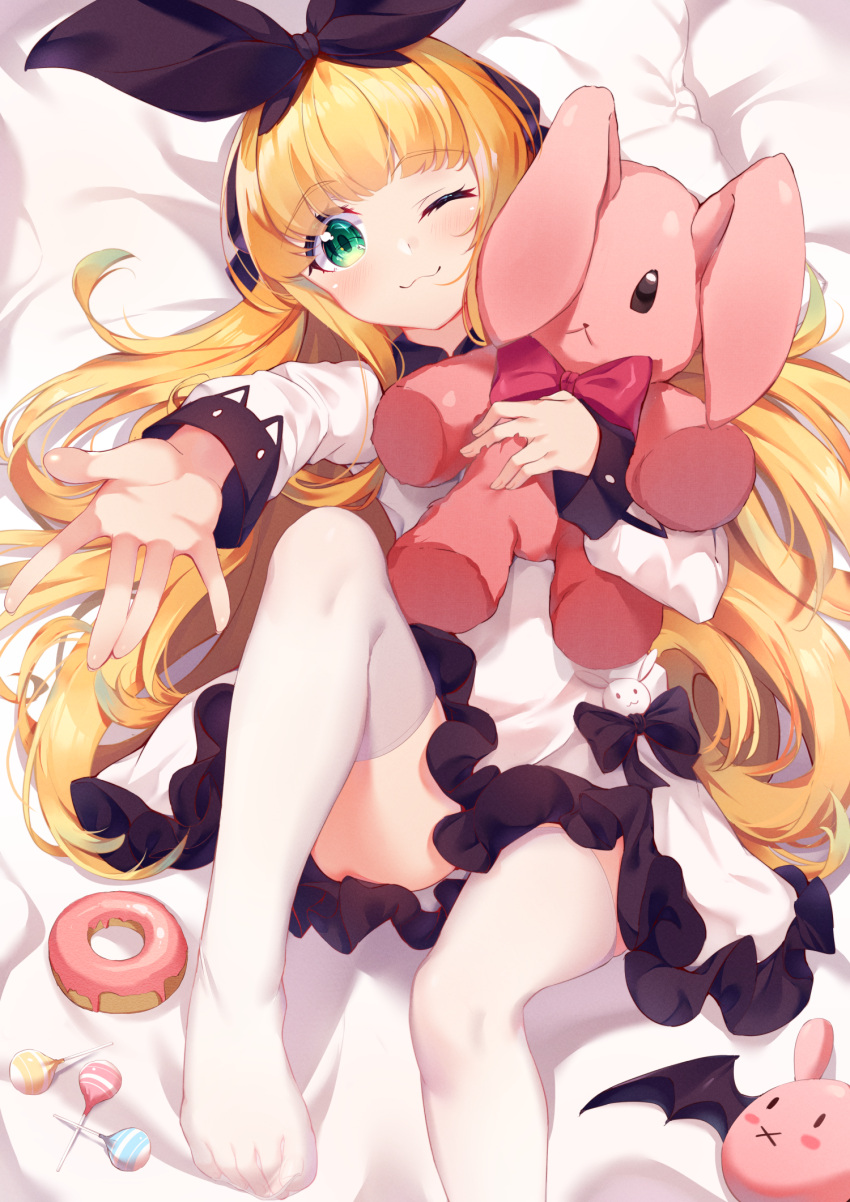 1girl ;3 bangs bed_sheet black_bow black_ribbon blonde_hair blush bow bowtie candy closed_mouth doughnut dress eyebrows_visible_through_hair food frilled_dress frills green_eyes hair_ribbon highres lollipop long_hair long_sleeves lying mononobe_alice nahaki nijisanji no_shoes object_hug on_back one_eye_closed outstretched_arm red_neckwear ribbon solo stuffed_animal stuffed_bunny stuffed_toy thigh-highs very_long_hair virtual_youtuber white_dress white_legwear