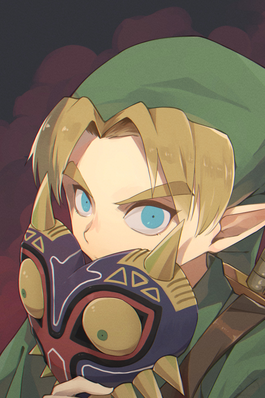 1boy absurdres bangs blonde_hair blue_eyes commentary_request eyebrows_visible_through_hair face_mask green_headwear hat highres holding holding_mask link looking_at_viewer male_focus mask nekochu_(masamura38b) parted_bangs pointy_ears solo the_legend_of_zelda the_legend_of_zelda:_majora's_mask