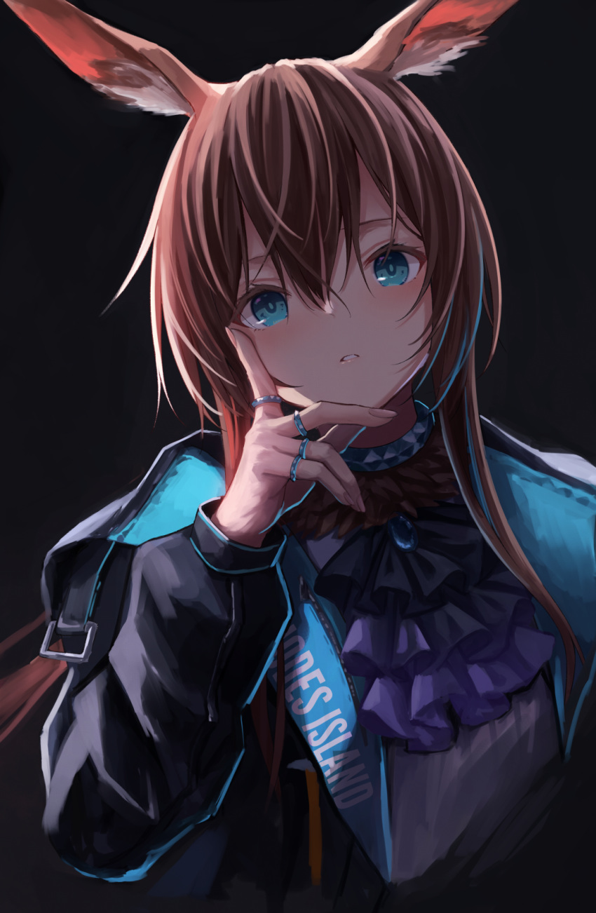 1girl amiya_(arknights) animal_ears arknights ascot bangs black_background black_jacket blue_eyes brown_hair choker english_commentary eyebrows_behind_hair hair_between_eyes hand_on_own_cheek hand_on_own_face hand_up highres jacket jewelry knoy3356 long_hair parted_lips rabbit_ears ring simple_background solo upper_body