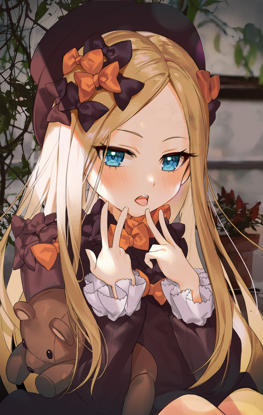 1girl abigail_williams_(fate/grand_order) bangs black_bow black_dress black_headwear blonde_hair blue_eyes blush bow breasts double_v dress fate/grand_order fate_(series) forehead hamube hands_up hat highres holding holding_stuffed_animal knees_up long_hair long_sleeves looking_at_viewer multiple_bows open_mouth orange_bow parted_bangs plant sitting solo stuffed_animal stuffed_toy teddy_bear tongue tongue_out v