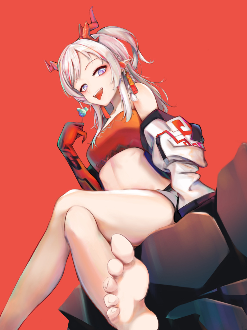 1girl arknights bare_legs bare_shoulders barefoot blue_eyes braid breasts candy crossed_legs dragon_horns earrings eyyy feet food foreshortening from_below gloves grin highres horns jacket jewelry lollipop looking_at_viewer medium_breasts medium_hair midriff nian_(arknights) off_shoulder open_mouth pointy_ears ponytail red_background red_gloves side_braid silver_hair simple_background sitting smile soles solo strapless thighs tongue tongue_out tubetop white_jacket
