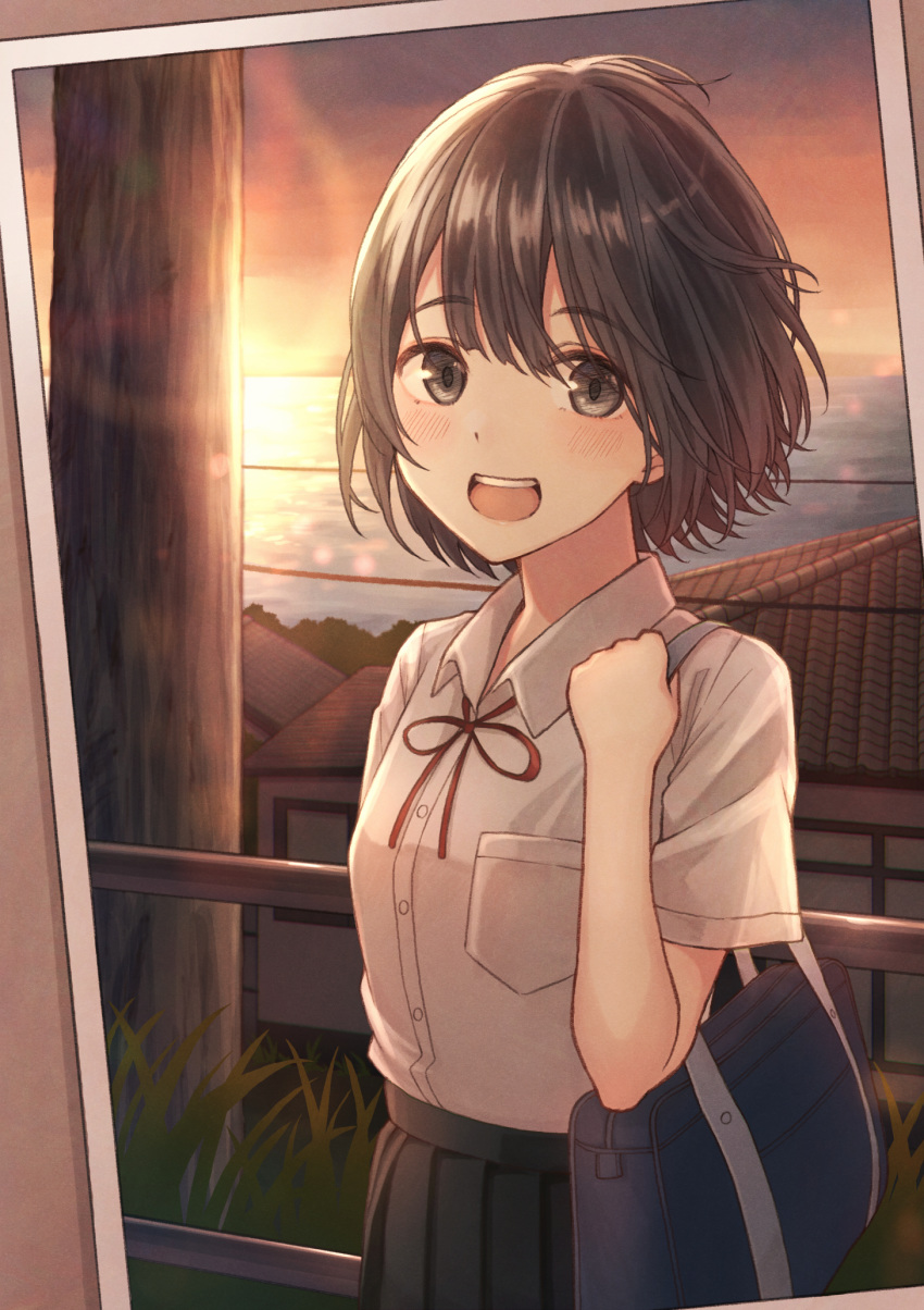 1girl :d adjusting_strap bag bangs black_skirt bob_cut border bow bowtie breasts brown_background brown_eyes brown_hair commentary cowboy_shot grass hair_strand highres holding holding_bag house light_blush looking_at_viewer messy_hair ocean open_mouth orange_sky original photo_(object) pleated_skirt pocket power_lines railing red_neckwear red_ribbon ribbon school_bag school_uniform skirt sky small_breasts smile solo sunset tanbonota46 telephone_pole tile_roof white_border wind