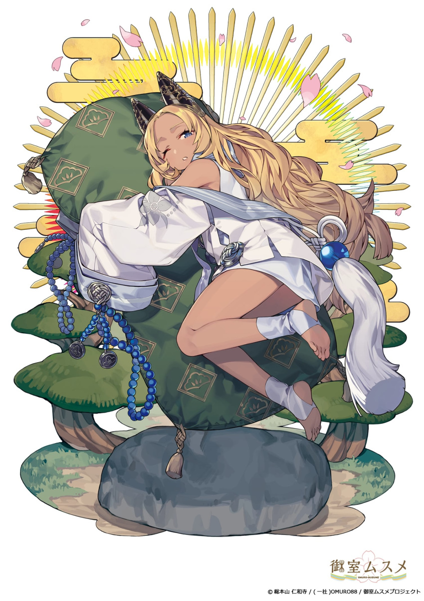1girl ;o bare_legs bare_shoulders barefoot beads blonde_hair blue_eyes blush bush copyright_request dark_skin egasumi feet from_behind full_body highres long_hair long_sleeves looking_at_viewer looking_back noy off_shoulder one_eye_closed orb parted_lips petals pillow pillow_hug rock simple_background sleeves_past_fingers sleeves_past_wrists soles solo tassel very_long_hair white_background