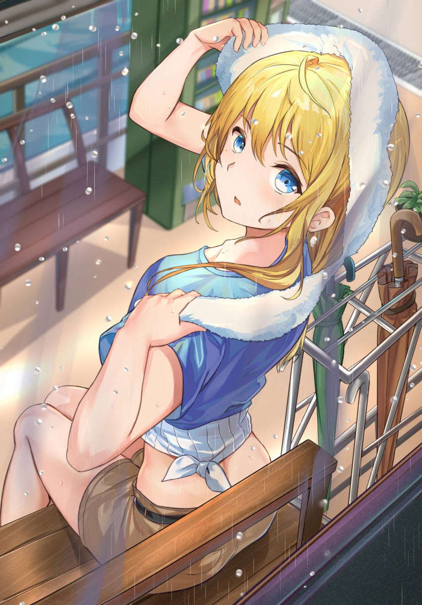 1girl ahoge arm_up belt bench blonde_hair blue_eyes blue_shirt blurry brown_shorts crop_top depth_of_field from_behind hand_up highres holding long_hair looking_at_viewer looking_back midriff mosta_(lo1777789) original parted_lips rain ribbed_shirt shirt short_shorts short_sleeves shorts sitting solo thighs tied_shirt towel umbrella undershirt vending_machine water white_shirt