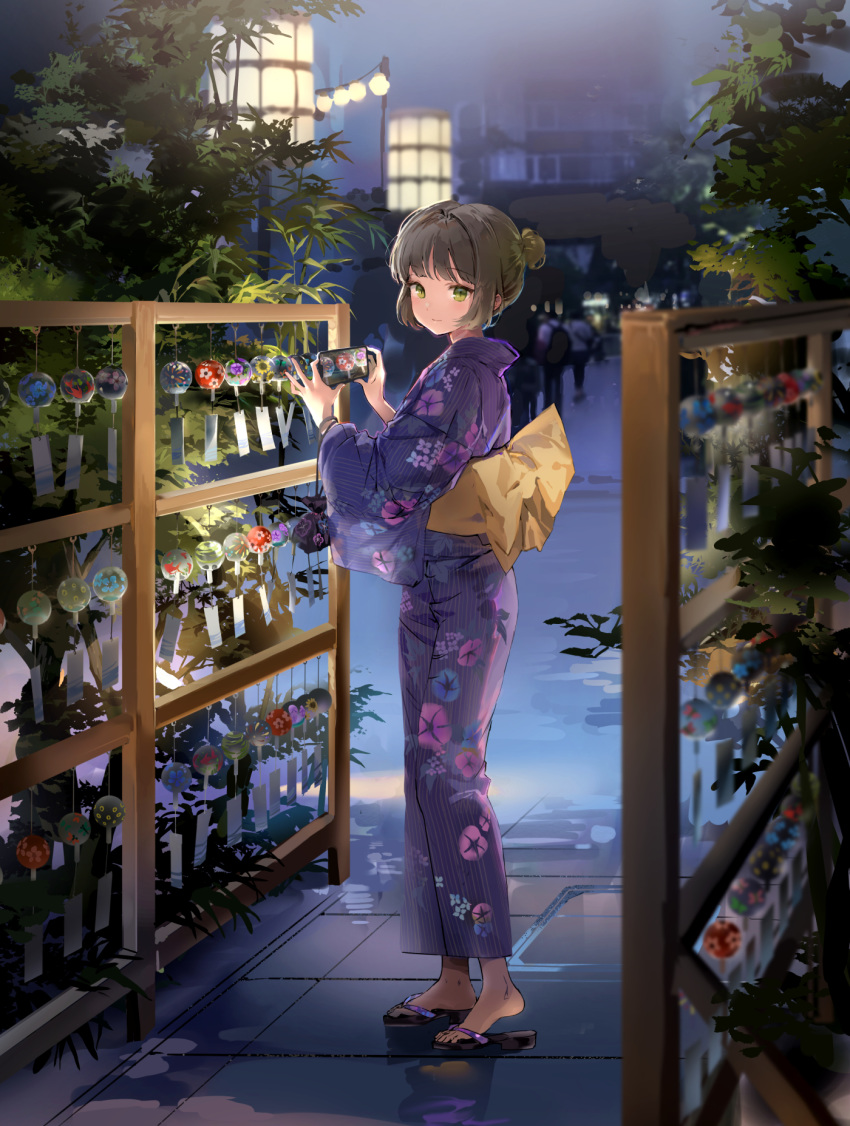 1girl anmi back_bow bangs black_footwear blinking blush bow brown_hair cellphone commentary_request cowboy_shot crowd eyebrows_visible_through_hair from_side full_body green_eyes hair_bun highres holding holding_phone japanese_clothes kimono large_bow long_sleeves looking_at_viewer looking_away looking_to_the_side night original outdoors phone purple_kimono red_eyes reflection short_hair smartphone solo_focus standing wide_sleeves wind wind_chime yellow_bow yukata