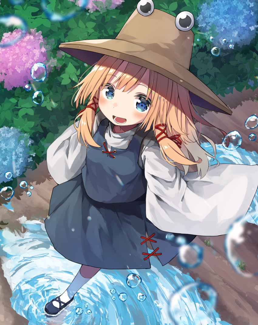 1girl black_footwear blonde_hair blue_eyes blue_skirt blue_vest blush brown_headwear bush commentary flower full_body hat highres hydrangea long_hair long_sleeves looking_at_viewer mamemochi moriya_suwako open_mouth outdoors path puddle ripples shirt shoes skirt smile socks solo touhou vest walking water_drop white_legwear white_shirt wide_sleeves