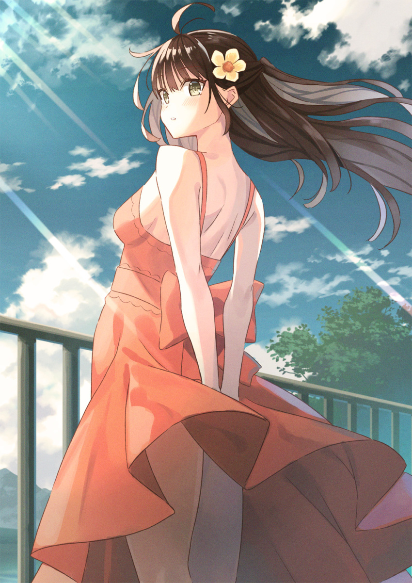 1girl ahoge arms_behind_back back bangs bare_shoulders blue_sky blush breasts brown_hair clouds dress eyebrows_visible_through_hair flower from_behind from_below green_eyes hair_flower hair_lift hair_ornament highres koh_rd long_hair medium_breasts original outdoors parted_lips railing red_dress sky thighs tree wind wind_lift