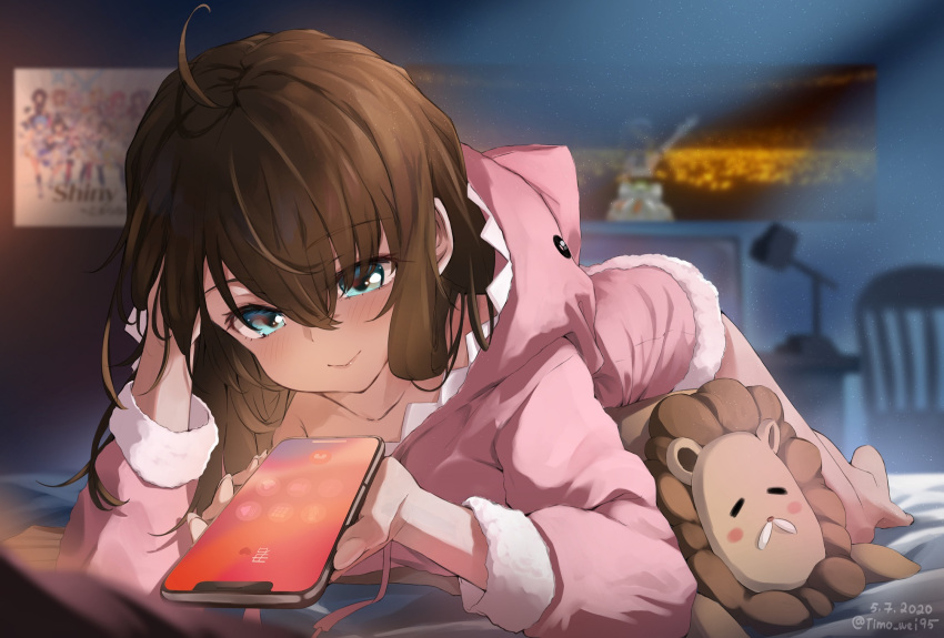 1girl ahoge bangs barefoot bed blue_eyes blush brown_hair casual cellphone dated eyebrows_visible_through_hair hair_between_eyes hair_down highres hololive indoors iphone iphone_x long_hair looking_at_phone lying natsuiro_matsuri on_stomach pajamas phone pink_hoodie poster_(object) shark_hood smartphone smile timo_wei95 twitter_username virtual_youtuber