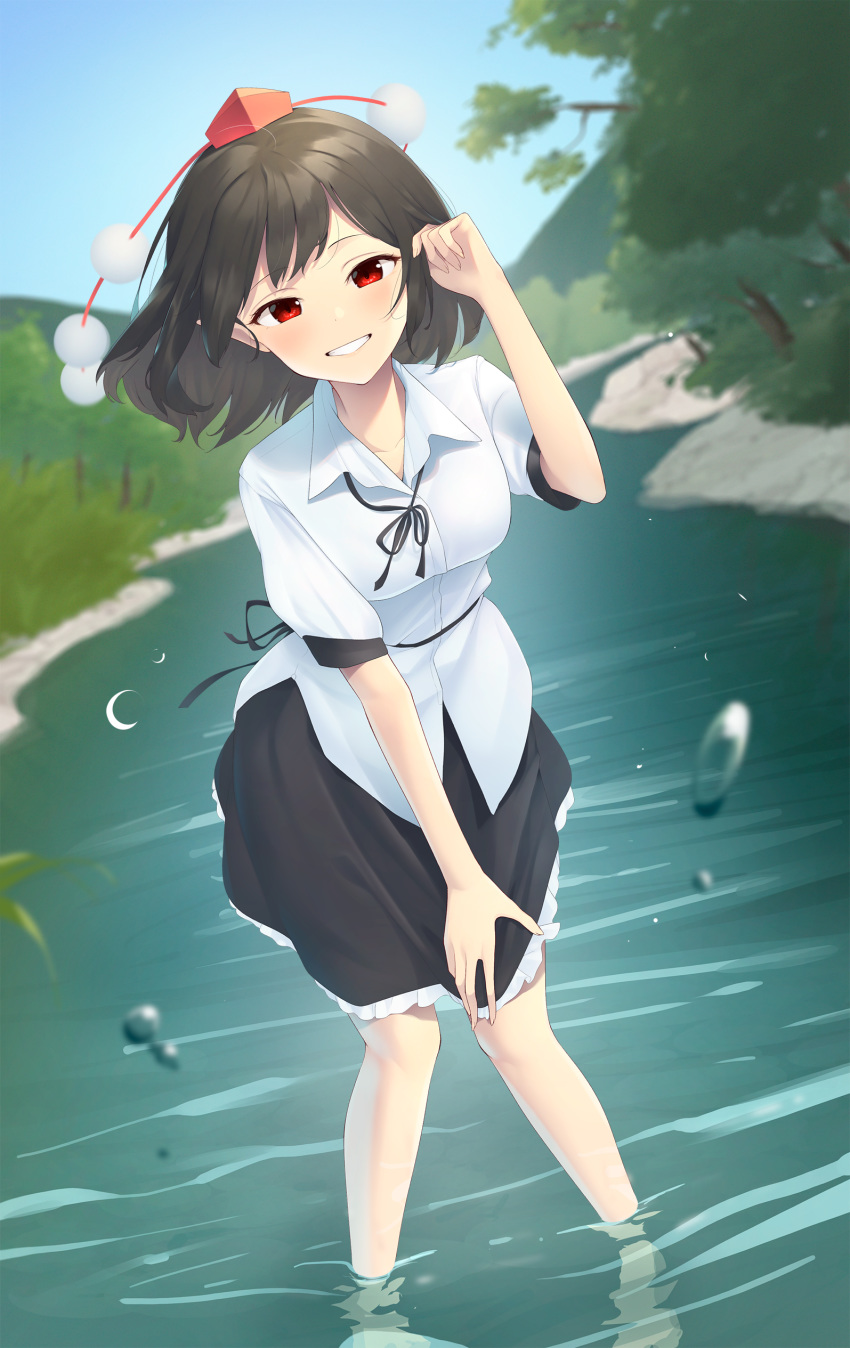 1girl absurdres black_hair black_neckwear black_skirt commentary day grin hand_up hat highres kanpa_(campagne_9) leaning_forward looking_at_viewer medium_hair mountainous_horizon neck_ribbon outdoors pointy_ears pom_pom_(clothes) red_eyes red_headwear ribbon river shameimaru_aya shirt short_sleeves skirt smile solo tokin_hat touhou tree wading water_drop white_shirt