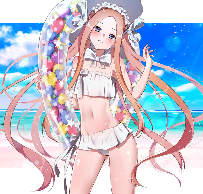 1girl abigail_williams_(fate/grand_order) abigail_williams_(swimsuit_foreigner)_(fate) bangs beach bikini blonde_hair blue_eyes bow commentary_request day eyebrows_visible_through_hair fate/grand_order fate_(series) flat_chest hair_bow hand_up heart highres holding holding_innertube innertube kawaruhi long_hair looking_at_viewer navel outdoors parted_bangs solo standing swimsuit very_long_hair white_bikini white_bow white_headwear
