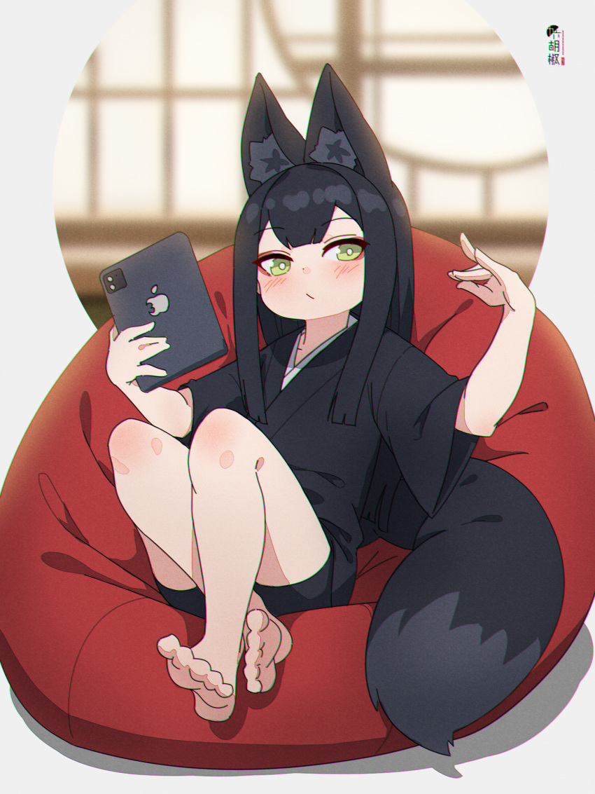 1girl animal_ear_fluff animal_ears bangs barefoot bike_shorts black_hair black_kimono black_shorts blurry blurry_background blush closed_mouth commentary_request depth_of_field eyebrows_visible_through_hair fox_ears fox_girl fox_tail full_body green_eyes hands_up highres holding japanese_clothes kimono kuro_kosyou long_hair looking_at_viewer original short_shorts short_sleeves shorts sitting soles solo tablet_pc tail wide_sleeves yui_(kuro_kosyou)