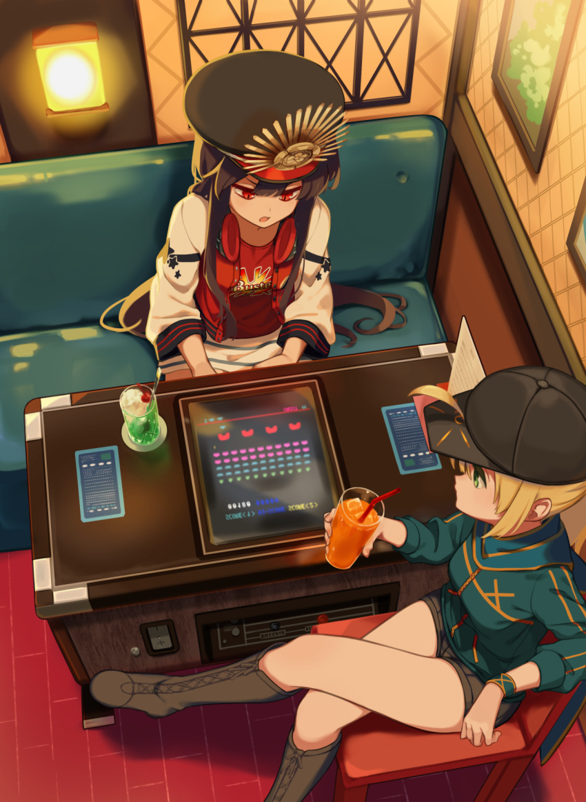 2girls ahoge artoria_pendragon_(all) baseball_cap black_hair blonde_hair blue_jacket booth boots buster_shirt cup drinking_glass drinking_straw family_crest fate/grand_order fate_(series) from_above green_eyes hat headphones headphones_around_neck highres indoors jacket jitome knee_boots kodamari letterman_jacket long_hair long_sleeves melon_soda multiple_girls mysterious_heroine_x oda_nobunaga_(fate) oda_nobunaga_(fate)_(all) peaked_cap red_eyes shorts sitting slit_pupils track_jacket very_long_hair