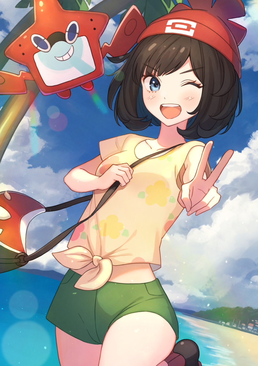 1girl bag bangs beanie black_hair blue_eyes blush clouds commentary_request day eyebrows_visible_through_hair eyelashes gen_4_pokemon green_shorts hat highres lens_flare looking_at_viewer one_eye_closed open_mouth outdoors palm_tree pokemon pokemon_(creature) pokemon_(game) pokemon_sm red_headwear rotom rotom_dex sand selene_(pokemon) shirt shore short_hair short_shorts short_sleeves shorts shoulder_bag sky smile t-shirt tanbonota46 tied_shirt tongue tree upper_teeth v water