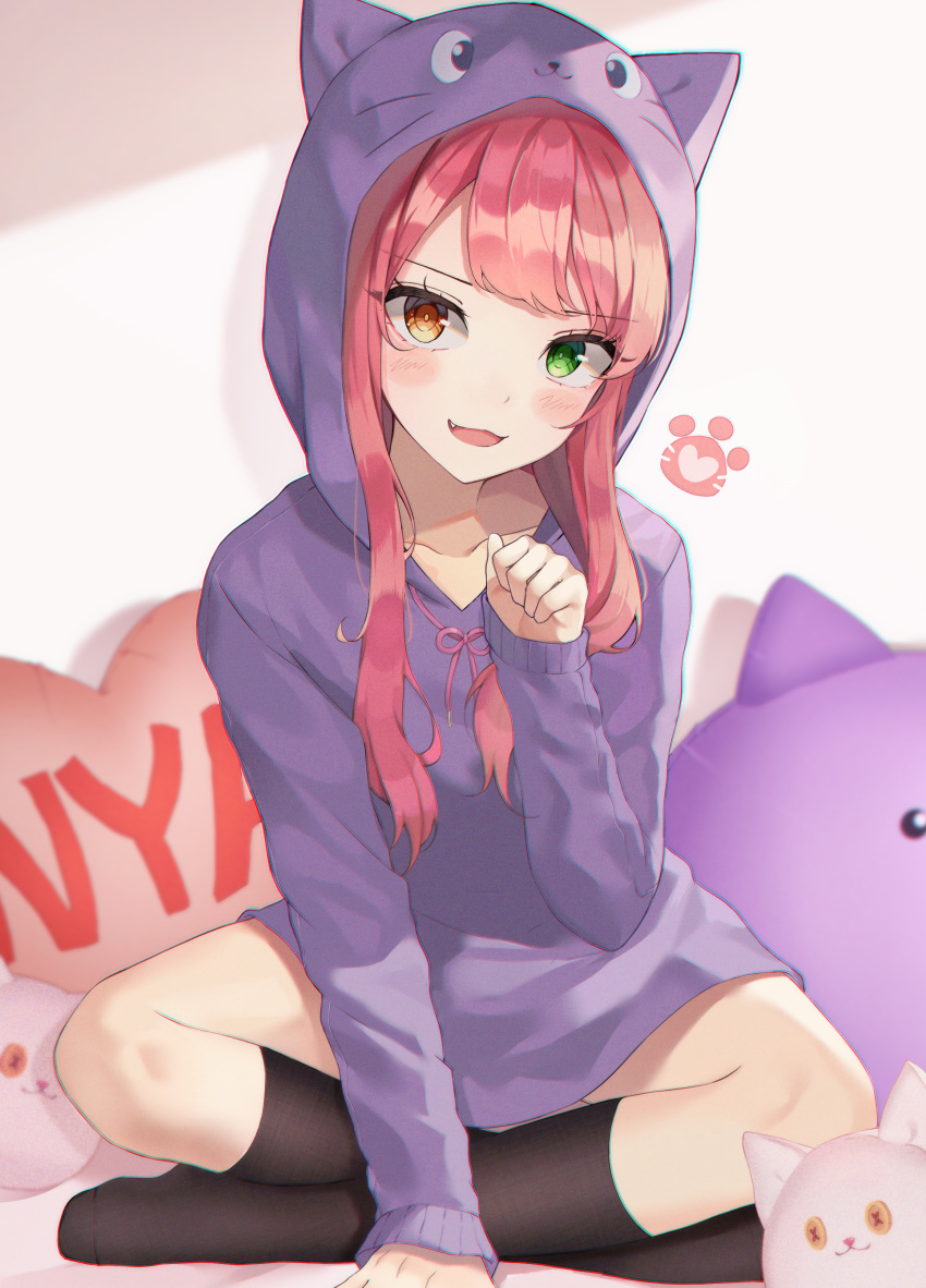 1girl :3 :d absurdres animal_hood bangs black_legwear blush cat_hood cat_pillow collarbone eyebrows_visible_through_hair fang green_eyes heart heart_pillow heterochromia highres hood kneehighs long_hair long_sleeves looking_at_viewer luxiel no_pants open_mouth orange_eyes original paw_pose pillow pink_hair pink_ribbon purple_hoodie ribbon sitting smile solo stuffed_animal stuffed_cat stuffed_toy swept_bangs v-shaped_eyebrows