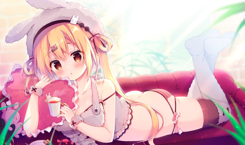 1girl animal_hat ass bangs bare_arms bare_shoulders blonde_hair brown_eyes bunny_hat candy cup feet food hair_ornament hairclip hat heart heart_pillow highres holding holding_cup indoors izumiyuhina long_hair looking_at_viewer lying on_stomach original panties pillow solo strap_slip striped striped_panties the_pose thigh-highs two_side_up underwear white_headwear white_legwear wrist_cuffs