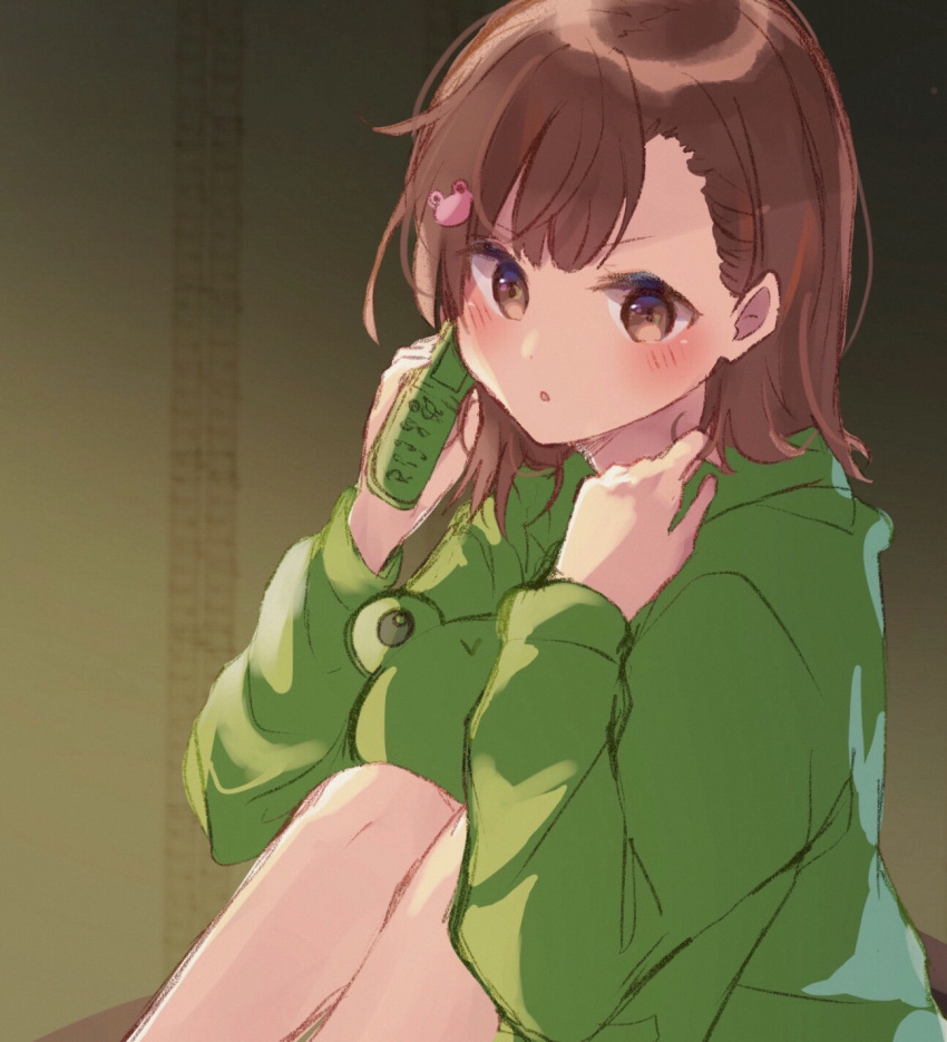 1girl :o bangs blush cellphone eyebrows_visible_through_hair flip_phone frog_hair_ornament green_hoodie hair_ornament hands_up highres himaneko. holding holding_phone hood hood_down hoodie indoors knees_up misaka_mikoto parted_lips phone sitting solo to_aru_kagaku_no_railgun to_aru_majutsu_no_index v-shaped_eyebrows