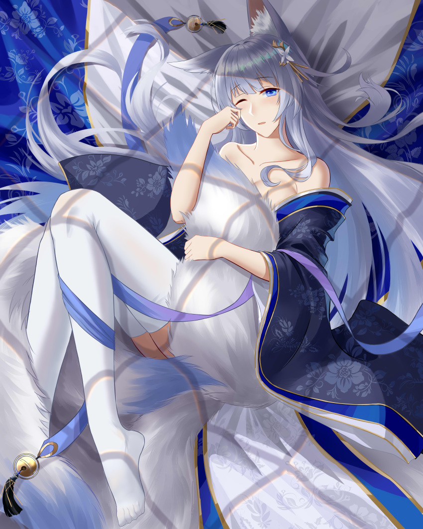 1girl absurdres animal_ear_fluff animal_ears azur_lane bare_shoulders bell blue_eyes blue_kimono collarbone fox_ears fox_girl frozen-sad grey_hair highres holding_tail japanese_clothes kimono kyuubi large_tail long_hair looking_at_viewer lying multiple_tails no_shoes off-shoulder_kimono on_back one_eye_closed shinano_(azur_lane) sleepy solo tail thigh-highs very_long_hair white_legwear white_tail
