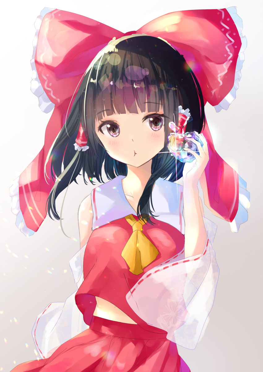 1girl :t absurdres arm_behind_back ascot bangs black_hair blunt_bangs blush bow breasts brown_eyes collarbone commentary_request detached_sleeves diffraction_spikes eating eyebrows_visible_through_hair food glint gradient gradient_background grey_background hair_bow hair_tubes hakurei_reimu highres holding holding_food looking_at_viewer medium_breasts medium_hair midriff_peek red_bow red_skirt red_vest rei_(farta_litia) sidelocks simple_background skirt skirt_set sleeveless solo touhou upper_body vest wide_sleeves yellow_neckwear