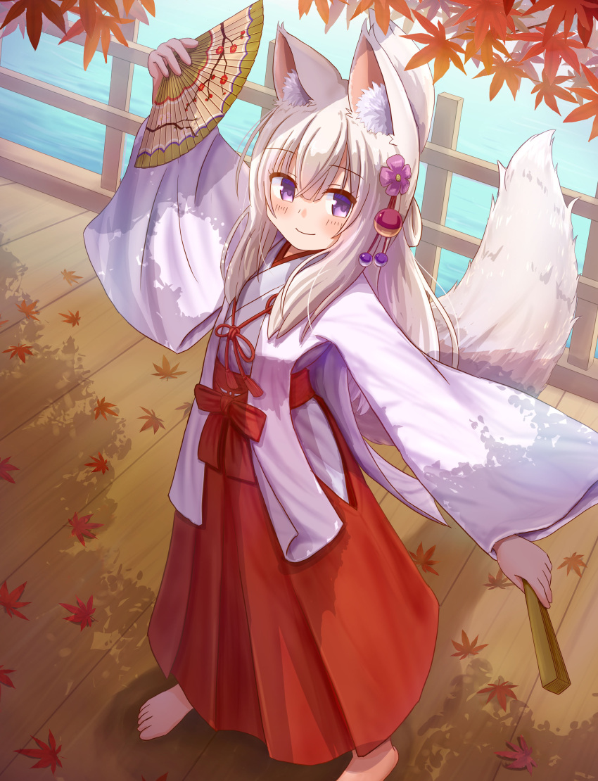 1girl absurdres animal_ear_fluff animal_ears arm_up autumn_leaves bangs barefoot blush closed_fan closed_mouth commentary_request day eyebrows_visible_through_hair fan flower folding_fan fox_ears fox_girl fox_tail full_body hair_between_eyes hair_flower hair_ornament hakama highres holding holding_fan iroha_(iroha_matsurika) japanese_clothes kimono leaf long_hair long_sleeves looking_at_viewer maple_leaf miko original outdoors purple_flower railing red_hakama silver_hair smile solo standing tail very_long_hair violet_eyes white_kimono wide_sleeves