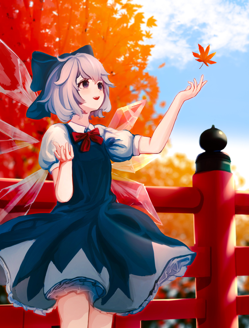 1girl :d absurdres bangs blue_bow blue_dress blue_eyes blue_hair blurry blurry_background bow bowtie breasts cirno depth_of_field dress eyebrows_behind_hair falling_leaves feet_out_of_frame fence hair_between_eyes hair_bow hanairomomiji highres ice ice_wings leaf looking_up maple_leaf open_mouth outstretched_arm petticoat puffy_short_sleeves puffy_sleeves red_bow red_neckwear short_hair short_sleeves sky small_breasts smile solo standing touhou tree wings