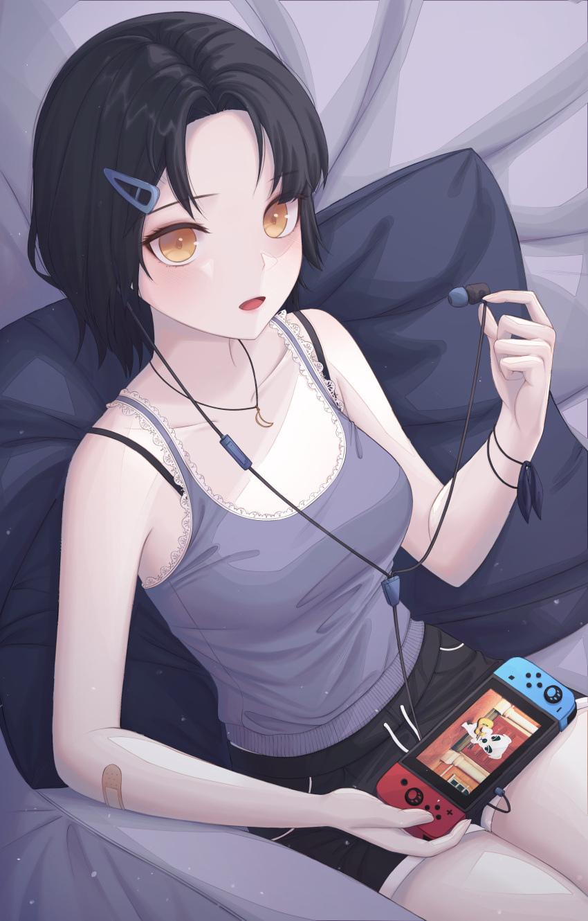 1girl absurdres bandaid bangs bare_arms bare_shoulders black_hair black_shorts bra_strap breasts camisole collarbone commentary_request dolphin_shorts earphones earphones_removed forehead game_console grey_shirt hair_ornament hairclip highres holding kongsi korean_commentary lace_trim looking_at_viewer medium_breasts nintendo_switch open_mouth orange_eyes original parted_bangs pillow shirt short_hair short_shorts shorts sitting sleeveless sleeveless_shirt solo spaghetti_strap