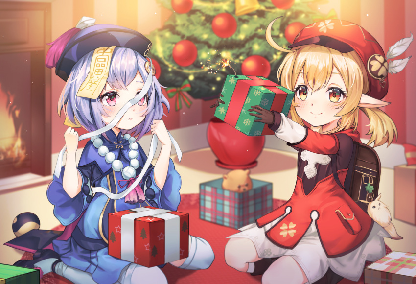 2girls absurdres aergia_c ahoge bag bead_necklace beads blush box cabbie_hat christmas christmas_tree dress feathers fireplace full_body genshin_impact gift gift_box hair_ornament hat high_heels highres huge_filesize indoors jewelry jiangshi klee_(genshin_impact) multiple_girls necklace pointy_ears qiqi seiza sitting smile stuffed_animal stuffed_toy teddy_bear thigh-highs