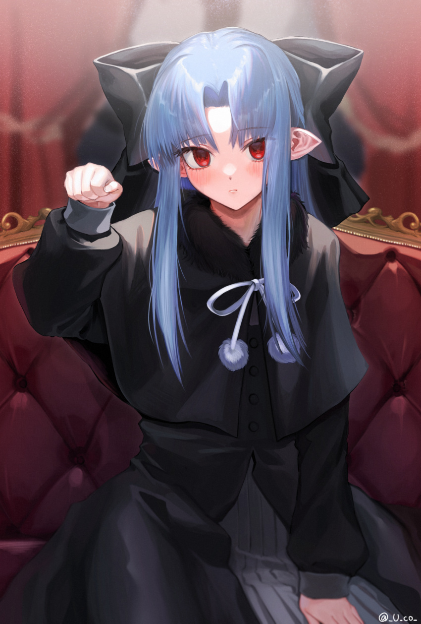 1girl bangs black_bow black_capelet black_dress blue_hair blurry blurry_background blush bow capelet closed_mouth couch cowboy_shot curtains dress eyebrows_visible_through_hair fur-trimmed_capelet fur_trim hair_bow highres indoors large_bow len_(tsukihime) long_hair long_sleeves looking_at_viewer neck_ribbon no_pupils on_couch parted_bangs paw_pose pointy_ears pom_pom_(clothes) red_curtains red_eyes ribbon sidelocks sitting solo tsukihime twitter_username u-co white_neckwear winter_clothes