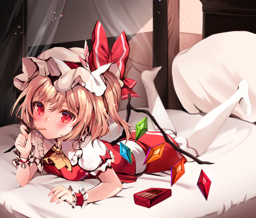 1girl ascot blonde_hair blush flandre_scarlet food hat hat_ribbon highres looking_at_viewer lying mob_cap mouth_hold on_bed on_stomach pantyhose pillow pocky puffy_short_sleeves puffy_sleeves red_eyes red_skirt red_vest ribbon shirt short_sleeves skirt solo touhou vest white_headwear white_legwear white_shirt wings wrist_cuffs yellow_neckwear zerocat