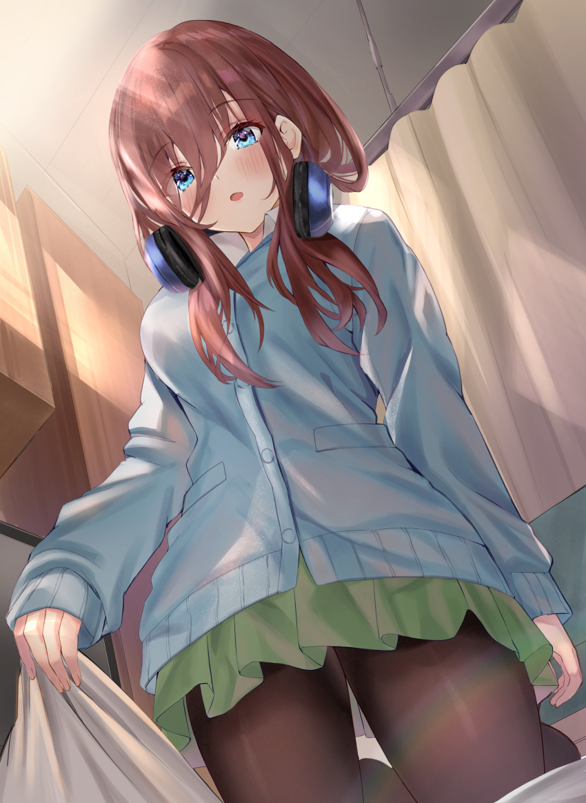 1girl :o absurdres bangs blue_cardigan blue_eyes blush breasts brown_hair brown_legwear cardigan curtains eyebrows_visible_through_hair from_below go-toubun_no_hanayome green_skirt hair_between_eyes headphones headphones_around_neck highres indoors kneeling large_breasts light_rays long_hair long_sleeves looking_at_viewer nakano_miku pantyhose pleated_skirt sheet_grab shirt skirt sleeves_past_wrists solo sunbeam sunlight toratora_(nanahaba) white_shirt