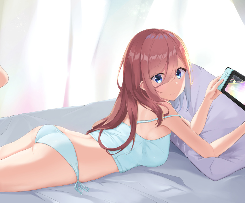 1girl ass bangs bed bed_sheet blue_camisole blue_eyes blue_panties breasts camisole controller curtains feet_up go-toubun_no_hanayome hair_between_eyes highres holding holding_controller light_blush light_particles long_hair looking_at_viewer looking_back lying medium_breasts nakano_miku nintendo_switch on_bed on_stomach panties pillow redhead side-tie_panties sleeveless smile solo strap_slip thighs tiara_(871220) underwear