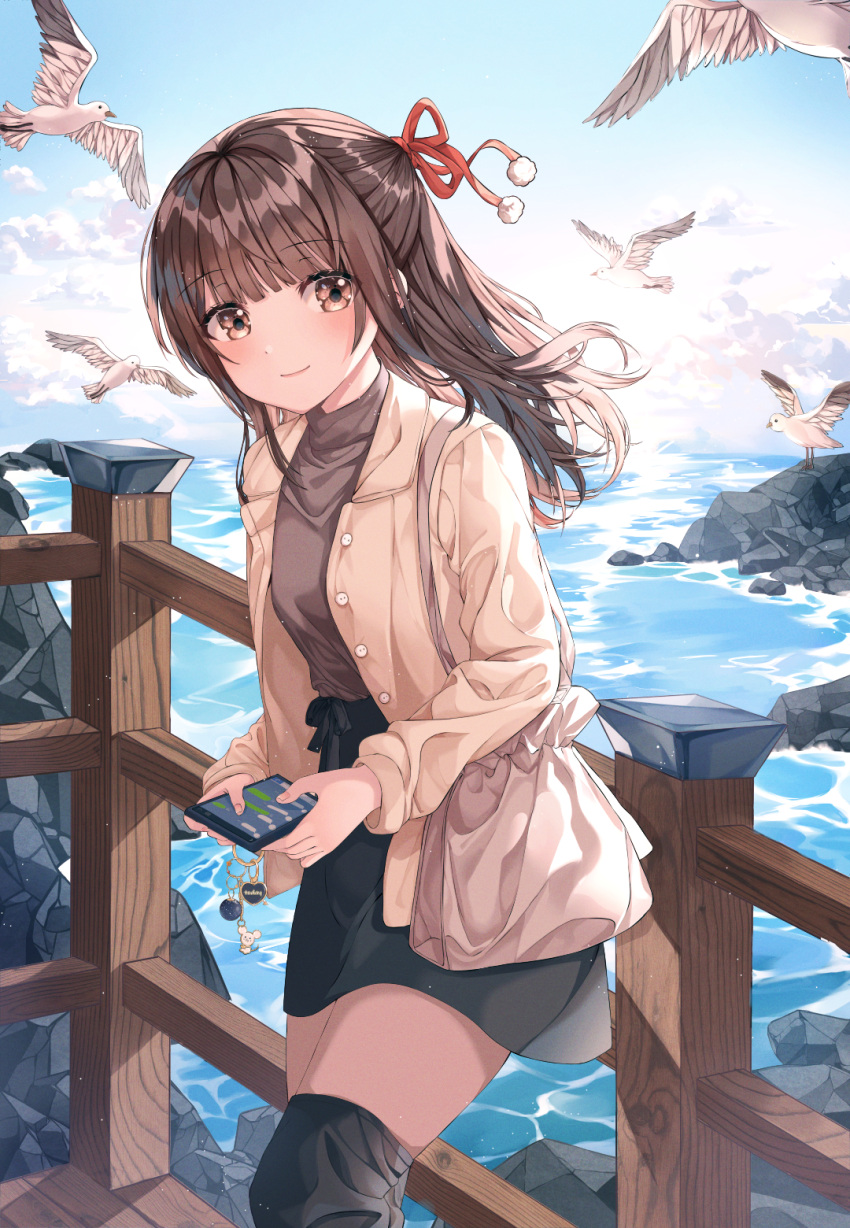 1girl bag bangs beige_jacket bird black_legwear black_skirt blunt_bangs blush breasts brown_hair brown_shirt cellphone closed_mouth clouds contrapposto day eyebrows_visible_through_hair feet_out_of_frame hair_ribbon handbag highres holding holding_phone long_hair looking_at_viewer nanna_(heyj2888) ocean original outdoors over-kneehighs phone pom_pom_(clothes) railing red_ribbon ribbon rock seagull shirt skirt small_breasts smartphone smile solo standing thigh-highs water