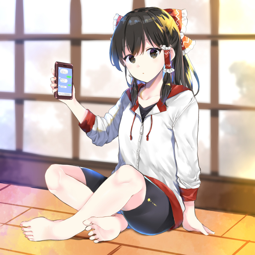 1girl :o alternate_costume bangs barefoot bike_shorts black_eyes black_hair black_shorts blurry blurry_background bow breasts cellphone collarbone commentary_request eyebrows_visible_through_hair frilled_bow frilled_hair_tubes frills full_body hair_bow hair_tubes hakurei_reimu hand_up highres holding holding_phone hood hoodie indian_style indoors long_hair long_sleeves looking_at_viewer phone red_bow shorts sidelocks sitting small_breasts smartphone solo sweater touhou white_sweater window yurara_(aroma42enola)