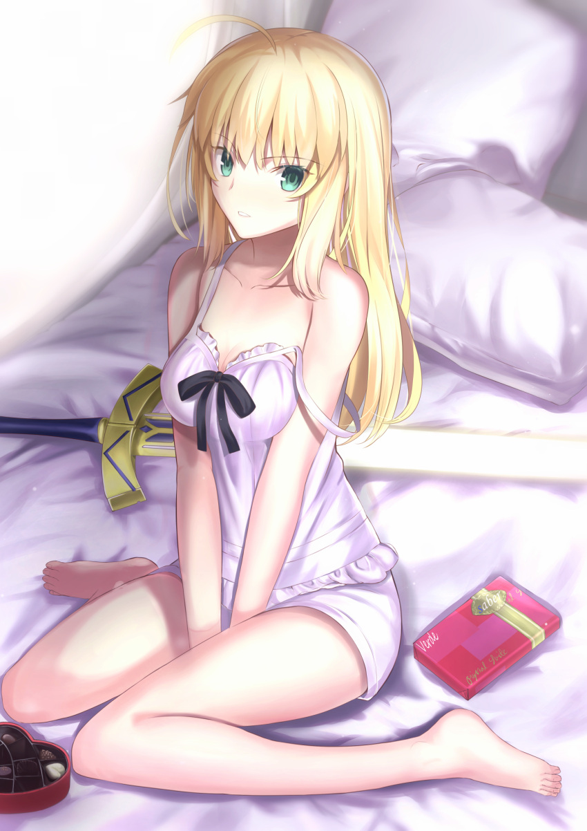 1girl alternate_costume alternate_hairstyle artoria_pendragon_(all) bed blonde_hair box breasts collarbone excalibur_(fate/stay_night) fate/grand_order fate_(series) gift gift_box green_eyes hair_down highres long_hair looking_at_viewer neko_daruma nightshirt on_bed pillow saber shirt shorts sitting sitting_on_bed small_breasts solo strap_slip sword thighs type-moon valentine wariza weapon white_shirt white_shorts