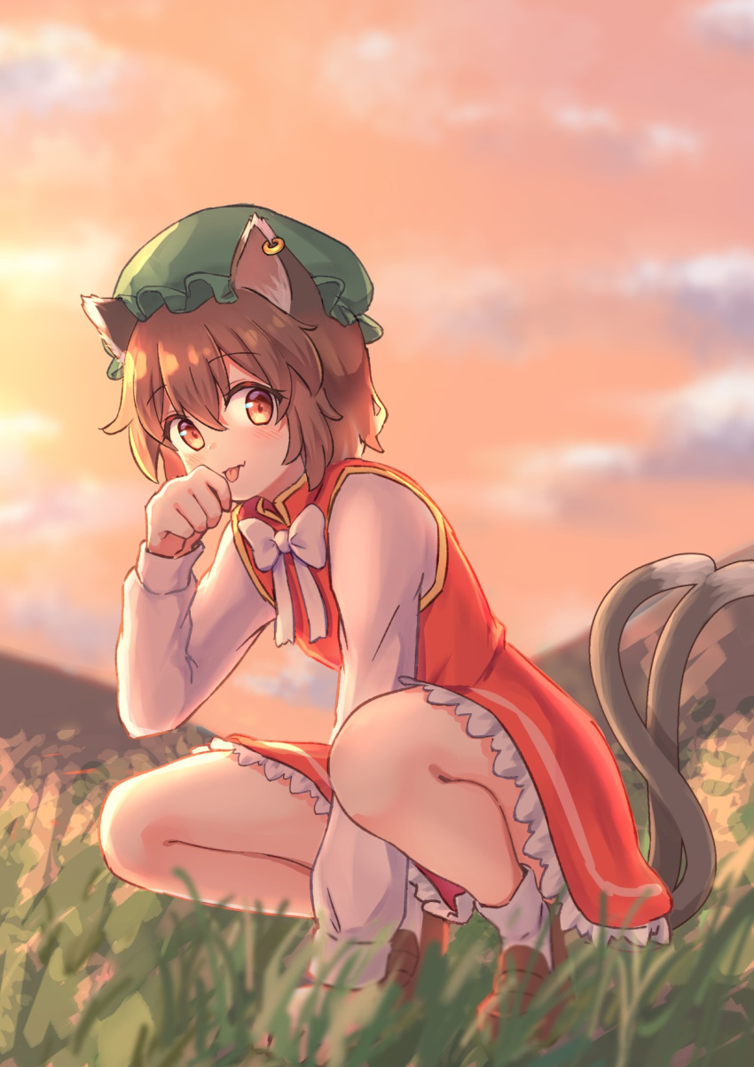 1girl :p animal_ears bangs blurry blush bow bowtie brown_eyes brown_hair cat_ears cat_tail chen clouds cloudy_sky commentary_request depth_of_field dress eyebrows_visible_through_hair flat_chest forneus_0 full_body gold_trim grass green_headwear hair_between_eyes hand_up hat highres jewelry licking long_sleeves looking_at_viewer mob_cap multiple_tails nekomata outdoors paw_pose petticoat red_dress short_hair single_earring sky solo squatting tail tongue tongue_out touhou twilight two_tails white_bow white_neckwear