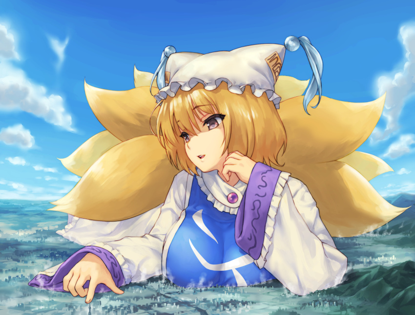 1girl animal_ears blonde_hair breasts city clouds commentary_request day dress eyebrows_visible_through_hair fox_ears fox_tail frills giant giantess hand_up hat highres large_breasts multiple_tails outdoors parted_lips pillow_hat pink_eyes short_hair sky smile solo tabard tail teston touhou upper_body white_dress yakumo_ran