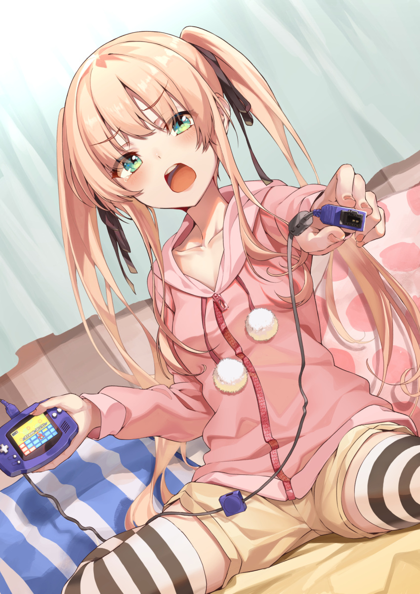 1girl bangs black_ribbon blonde_hair blush breasts brown_shorts collarbone commentary_request curtains game_boy_advance green_eyes hair_ribbon handheld_game_console hands_up highres hood hood_down hoodie kabu_(niniko2ko) long_hair open_mouth original pillow pink_hoodie ribbon short_shorts shorts sitting small_breasts solo striped striped_legwear striped_pillow thigh-highs twintails upper_teeth wariza zipper