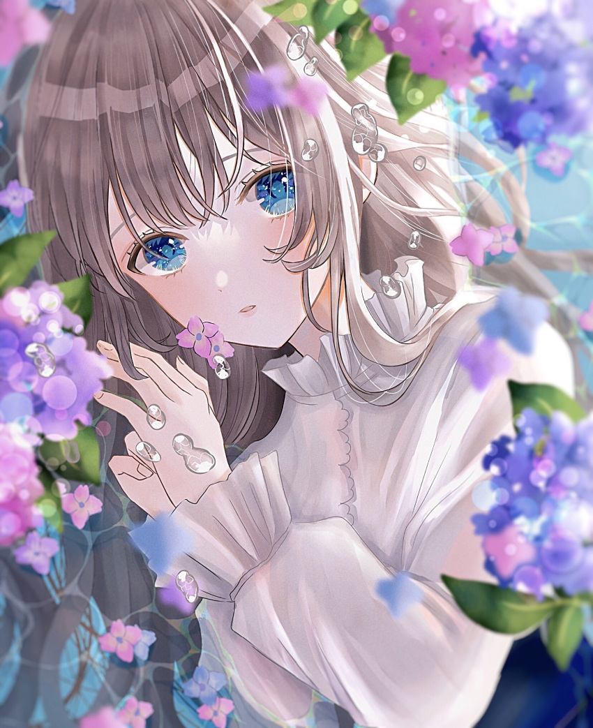 1girl bangs blonde_hair blue_eyes blue_flower blurry blurry_background blurry_foreground blush drinkyog flower frilled_shirt_collar frilled_sleeves frills highres holding holding_flower long_hair long_sleeves looking_at_viewer original parted_lips pink_flower purple_flower shirt solo water_drop white_shirt