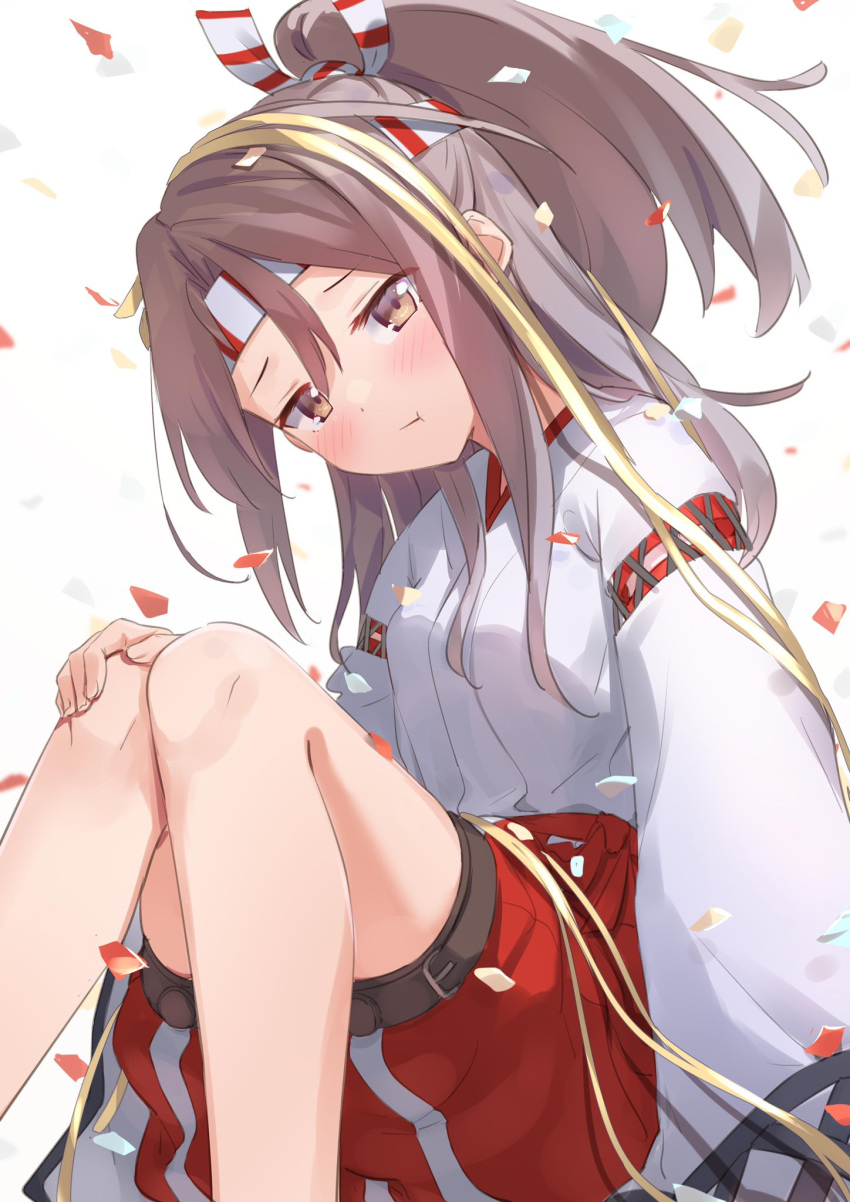 1girl blush brown_eyes commentary_request confetti hachimaki hair_between_eyes hakama_pants headband high_ponytail highres japanese_clothes kantai_collection light_brown_hair long_hair looking_at_viewer natsuki_(gedo) pants red_pants sitting solo zuihou_(kancolle)